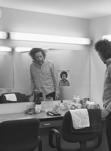 Destroyer Press Photo for Dan's Boogie. Dan Bejar in black and white in what looks like a changing room.