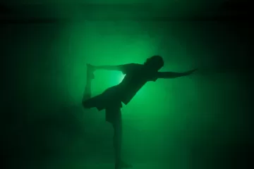 Antony Szmierek - Yoga teacher single cover, the artist practicing a yoga pause in a smoky dimly lit green room.
